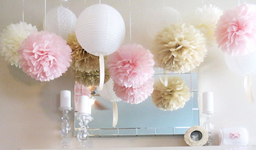 Украшение стены, помещения нежно-розовым бумажными помпонами и помпонами цвета латте в комбинации с белыми подвесными фонариками из бумаги